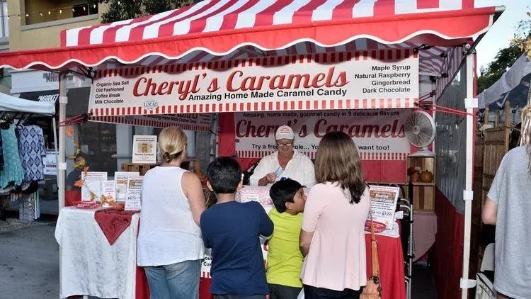 The red and white striped Cheryl's Caramels booth at the Oceanside Sunset Market