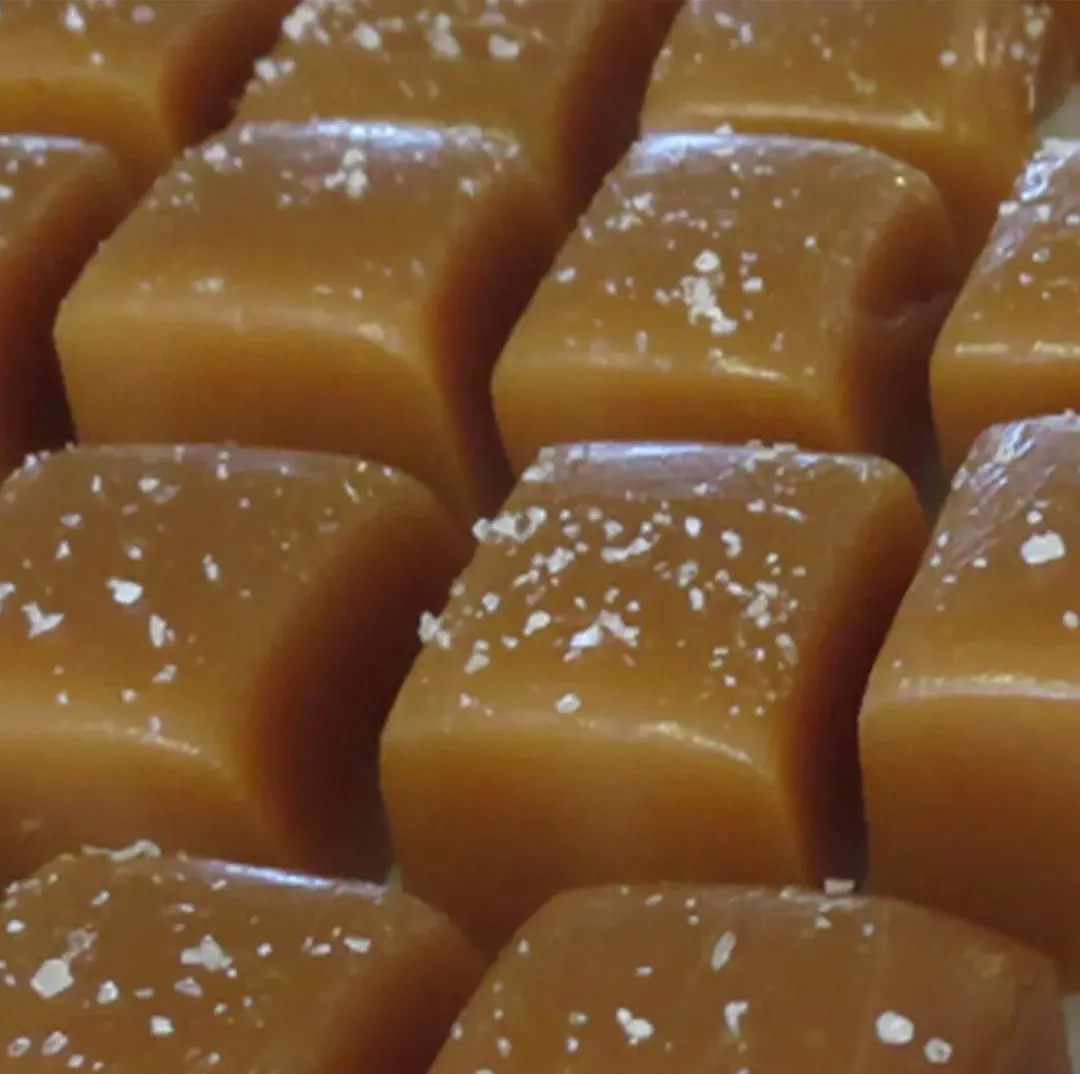 Rows of glossy sea salt caramels topped with flakes of salt
